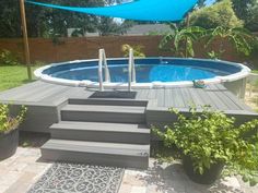 an above ground swimming pool with steps leading up to it and plants in the foreground