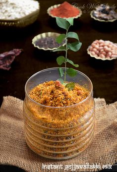 a small plant sprouts from the top of a glass bowl filled with food