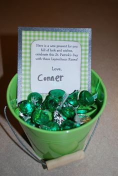 a green bowl filled with lots of candy next to a sign that says, love