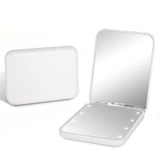 a white mirror sitting on top of a table next to a square shaped object in front of it