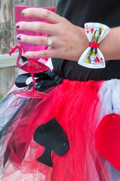 a close up of a person's hand wearing a red and black tutu skirt