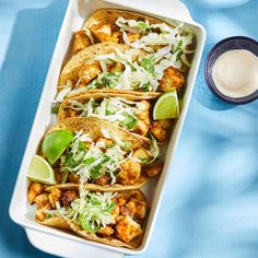 chicken tacos with cilantro, lime and sour cream on a blue tablecloth