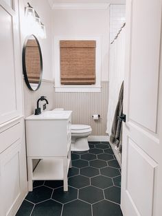 a white toilet sitting next to a sink in a bathroom