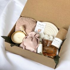 an open box filled with personal care items on top of a white bed sheet,