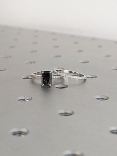 a black diamond ring sitting on top of a metal surface