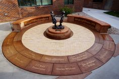 there is a statue in the middle of a circle with names on it and two people holding hands