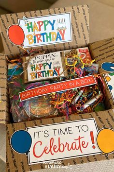 an open birthday box filled with lots of party supplies and decorations for someone's birthday