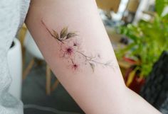 a woman's arm with a flower tattoo on the left side of her arm