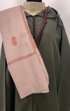 Introducing the Nur Sandala Shawl, a stunning piece that features 25 sacred Sandala patterns meticulously hand-embroidered across the fabric. The Nur Shawl is 12-inch wider than our popular Zayn Shawl, offering even more elegance and versatility. Crafted from premium soft wool, this shawl is woven in Kashmir using traditional mechanized looms, producing five to six scarves daily. Each piece is hand-dyed, and the intricate embroidery is done by skilled farmer-artisans in the villages, utilizing t Traditional Brown Pashmina Shawl With Patterns, Traditional Brown Embroidered Shawl, Traditional Embroidered Brown Shawl, Beige Traditional Wear With Intricate Embroidery For Eid, Traditional Beige Wear For Eid, Beige Traditional Wear For Eid, Beige Traditional Wear For Eid Ceremonies, Embroidered Border Shawl For Traditional Ceremonies, Bohemian Beige Traditional Wear For Festivals