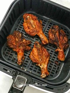 four pieces of chicken sitting on top of an air fryer