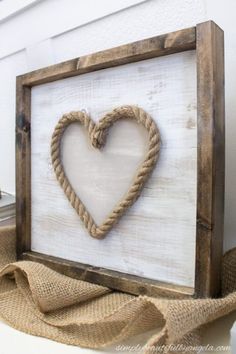 a wooden frame with a rope heart on it