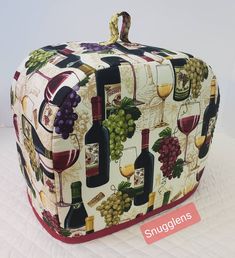 an upholstered box with wine glasses and bottles on it, sitting on a white surface