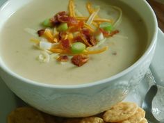 a white bowl filled with soup and crackers