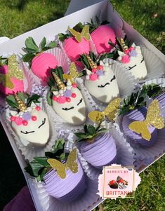 unicorn cupcakes are in a box on the grass