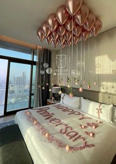 a large bed in a room with balloons hanging from the ceiling