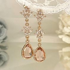 Discover timeless elegance with these **Art Deco Blush Earrings**. Perfect for the modern bride, these champagne pink earrings add a touch of sophistication and glamour to any bridal look. Inspired by Art Nouveau design, these teardrop earrings are ideal for weddings and special events. **Key Features - **Material High-quality alloy with champagne gold tone - **Stones Champagne pink crystals - **Design Art Deco and Art Nouveau - **Size 4,9 cm in length    1,93 inch - **Closure Safe and comfortab Crystals Design, Rose Gold Bridal Jewelry, Art Nouveau Earrings, Earrings For Bride, Teardrop Bridal Earrings, Design Art Nouveau, Blush Earrings, Art Nouveau Earring, Wedding Earring