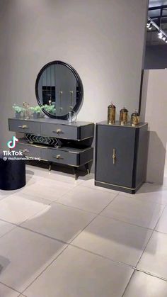 a black and white dresser with a mirror on it's top shelf in a room