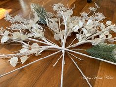 a bunch of branches with white flowers and leaves arranged on the floor next to each other