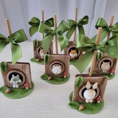 there are many small wooden boxes with animals in them and green bows on the top