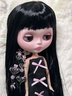 a close up of a doll with long black hair