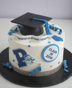 a graduation cake decorated with blue and silver confetti, black cap and tassels