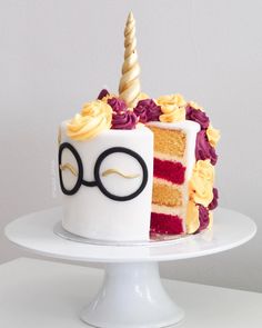 a cake with glasses on top and a slice missing from it that is sitting on a plate