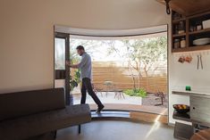 a man walking into a living room through an open door