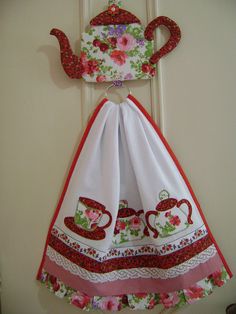 the dress is hanging on the door with flowers and teapots printed on it