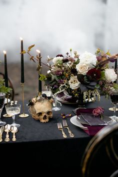 the table is set with silverware, candles and flowers in vases on it