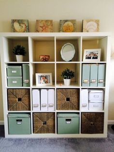 a white bookcase filled with lots of boxes and baskets on top of it's sides