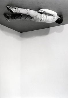 a black and white photo of a person laying on the ceiling