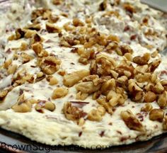 a pizza with nuts on it sitting on a pan