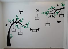 a tree with birds and frames hanging from it's branches