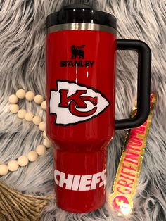 the kansas chiefs travel mug is next to a candy bar and a christmas ornament