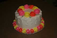 a white cake with flowers on it sitting on a table