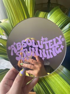 a person holding up a mirror with the words absolutely shining on it's side