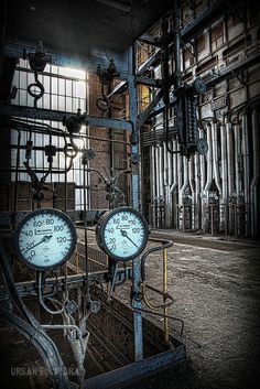 there are two clocks in the middle of an industrial building