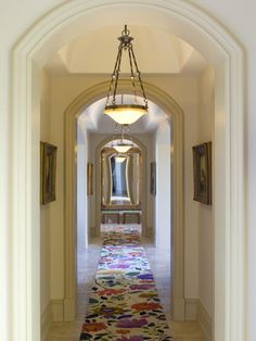 an archway leading to a hallway with a rug on the floor and lights hanging from the ceiling