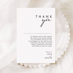 a white thank card with the words, thank you written in cursive font