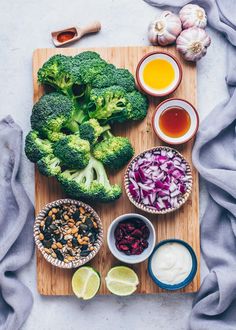 broccoli, onions, and other ingredients on a cutting board next to some sauces