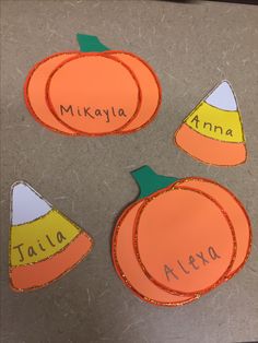 three paper pumpkins with the names of their respective children's names on them