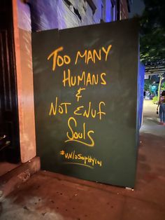 a sign on the sidewalk that says too many humans and not - ugly souls