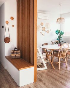 a dining room table and chairs with wooden slats on the wall