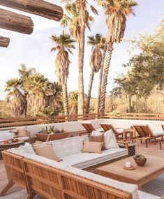 an outdoor patio with wooden furniture and palm trees in the background that reads, the joshua treehouse saguaro national monument