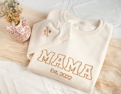 Chest and Sleeve Embroidered Crewneck for Mom Grandmother Gigi, Nanny, Grammie, Grammy MAIN PHOTO: SWEET CREAM HEATHER WITH GOLDEN PECAN THREAD This item is fully customizable! - You an choose the color of your thread - You can customize the sleeve with your loved ones initial, name or your favorite quote! - You can personalize the collar with the name and the sleeve with names, dates or initials The perfect gift for your significant other, or your newly engaged or married friends or family ❤️ N White Tops With Embroidered Graphics For Mother's Day, White Embroidered Tops For Mother's Day, White Tops With Letter Embroidery For Mother's Day, Embroidered White Tops For Mother's Day, Custom Embroidered White Tops For Mother's Day, Newly Engaged, Embroidered Crewneck, Mama Sweatshirt, Custom Sweatshirts