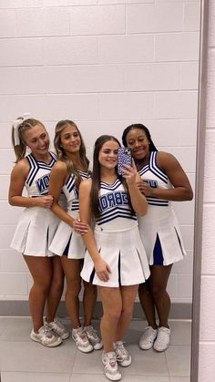 the cheerleaders are posing for a photo in front of a mirror with their cell phone