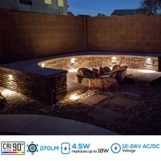 an outdoor fire pit with lights on the sides and in between it's walls