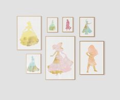 the princess silhouettes are hanging on the wall in front of some framed art pieces