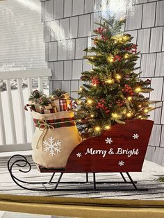 a small christmas tree sitting on top of a wooden sled