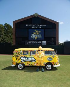 a yellow van parked in front of a baseball stadium